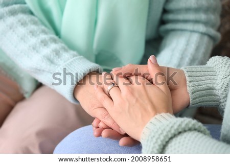 Hands of daughter and her mother after chemotherapy, closeup