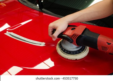 Hands with daul action polisher. polishing on car surface. hand and foam pad in blur motion from vibration  of polisher machine