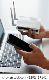 Hands of developer connecting smartphone to wi-fi router via application