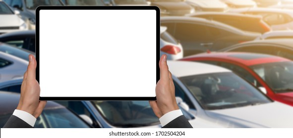Hands with digital tablet on a background of rows of cars. Car sales.