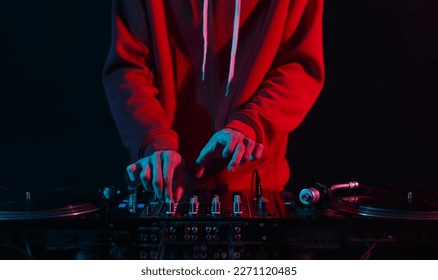 Hands of DJ mixing vinyl records with sound mixer in close up. Professinal club disc jokey plays set on party - Shutterstock ID 2271120485