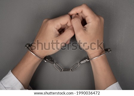 hands of a doctor in handcuffs close up,arrest of a surgeon.
