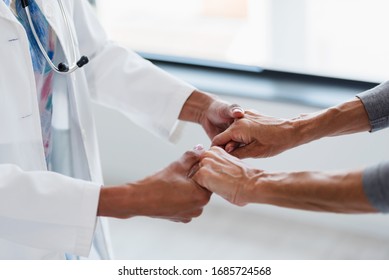 Hands Of A Doctor Holding Hands Of Elderly Patient. Checking Symptoms Of Stroke. Medical Care And Support Concept.