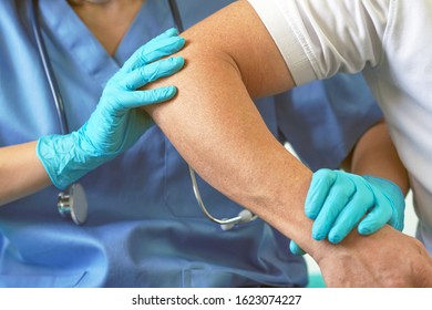 Hands  Of Doctor Holding Patient Shoulder, Examination Of Patients In The Hospital. Surgeon, Anesthetist Holding Shoulder Patient. Professional Surgery, Therapy, Medical Recovery Concept.