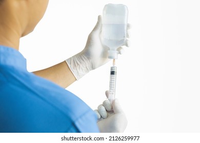 Hands of a doctor or nurse wearing rubber gloves and using a syringe to suck Sodium Chloride in a clinic or hospital alone with a white background. - Powered by Shutterstock