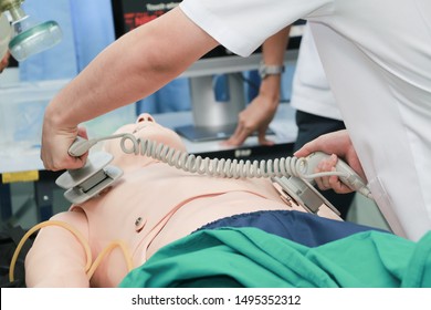 Hands Of Doctor  Physician Performning Cardioversion With Defibrillator On A Mannequin During Advance Cardiac Life Support Course Training.Healthcare Concept