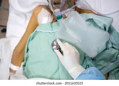 Hands Of Doctor Use The Stethoscope For Listen To Heart Or Breathing,check The Lung,examination Treatment Of Infected Patient Lying In Hospital Bed,elderly Patient With Oxygen Mask In Coma At ICU Room