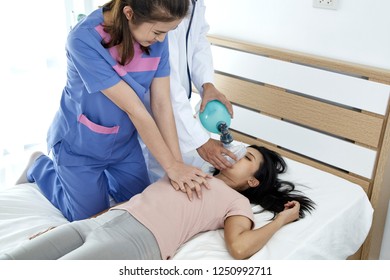 Hands of doctors giving cardiac massage and resuscitation to a female patient in the bedroom, Concept of Emergency Medical Team