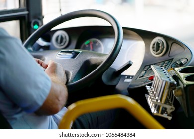 Hands of driver in a modern bus by driving.Concept - close-up of bus driver steering wheel and driving passenger bus - Shutterstock ID 1066484384