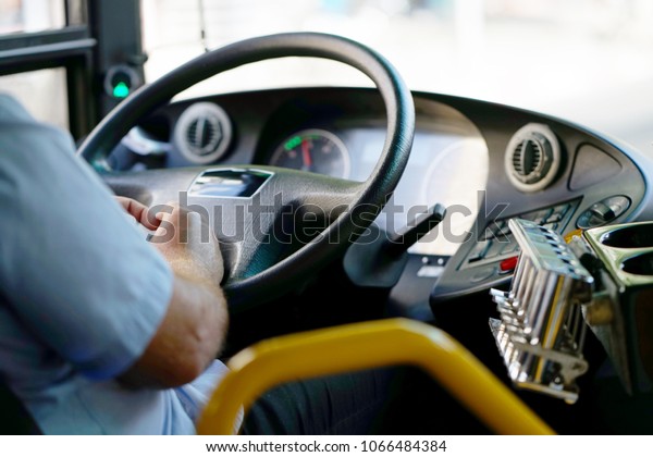 Hands of\
driver in a modern bus by driving.Concept - close-up of bus driver\
steering wheel and driving passenger\
bus