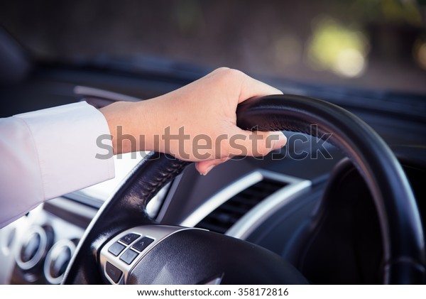 Hands of driver on\
steering wheel. Vintage