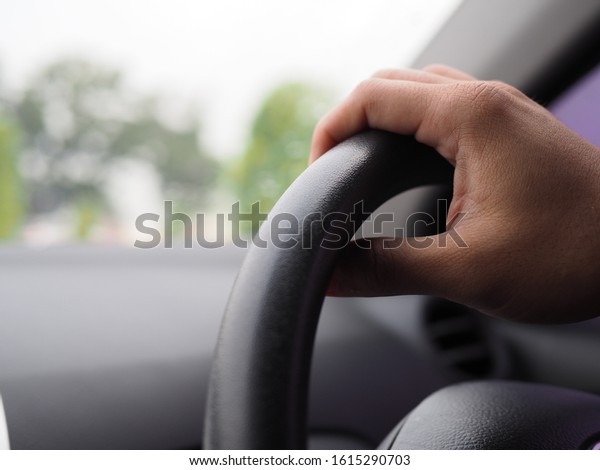 Hands driving a car in home town, safety drive\
and car insurance\
concept.
