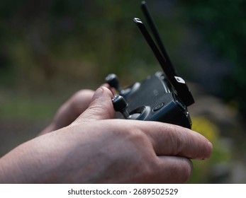 Hands with drone and remote controller in background close up shot selective focus - Powered by Shutterstock - Get 15% off with code: PIKWIZARD15