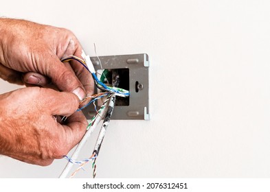 The hands of an elderly man mount a rosette in a white wall. Repair of the apartment. Internet