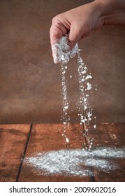 The hands of an elderly, plump woman are kneading dough on a wooden table. Preparation of dough for a festive cake, pizza