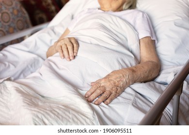 Hands Of Elderly Sick Woman Lying On Her Bed At Home. Concept: Age, Social Help Lonely, Health Care And Elderly People. Close Up. Selective Focus