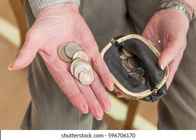 Hands Of An Elderly Woman With British Money In The Palm Of Her Hand And An Open Purse Containing Coins.