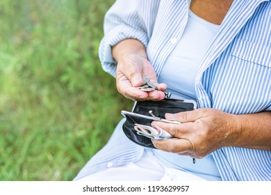 Hands Of An Elderly Woman Holding A Purse With Money, Pension