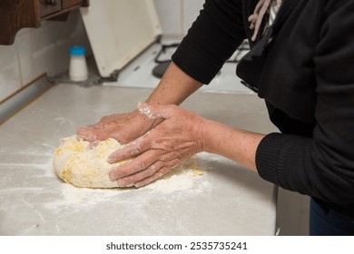 Hands of an elderly woman making dough to bake bread, pies, and pastries. Traditional cuisine. - Powered by Shutterstock