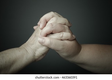 Hands of elderly and young women on black background. Toned. - Shutterstock ID 463360391