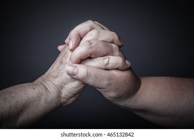 Hands of elderly and young women on black background. Toned. - Shutterstock ID 465132842