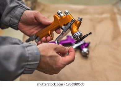 The Hands Of An Employee Of The Shop Painting And Cleaning Of The Spray Gun, Close-up