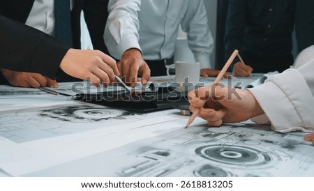 Hands engaged in a discussion over graphical design plans and technical drawings during a collaborative team meeting in a modern office setting. SACTR