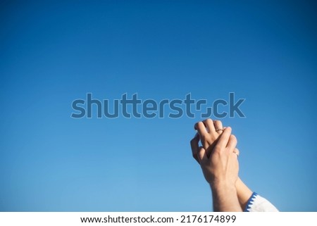 The hands of the engaged on the background of the sky. Sunny day . Young hands.Blue background hands up in the air. Selective focus
