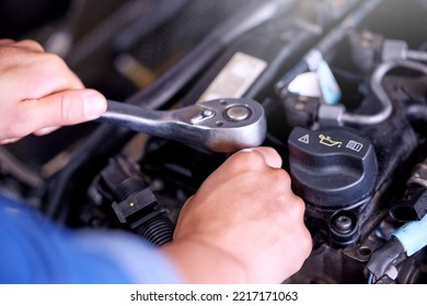 Hands, Engine And Mechanic With A Man Engineer Working With A Spanner Tool Under A Car Hood In A Workshop. Worker, Industry And Engineering With A Male Maintenance Professional At Work In His Garage