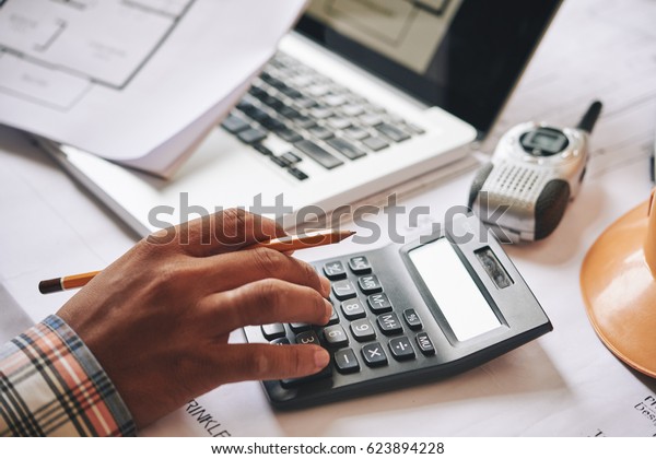 Hands\
of engineer calculating budget estimate for\
project