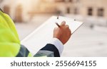 Hands, engineer and clipboard in city for checklist, inspection notes or safety compliance. Person, writing or outdoor with documents for urban development, project management or supervisor paperwork