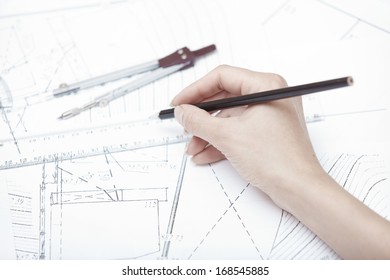 Hands of engineer working on a construction plan - Shutterstock ID 168545885