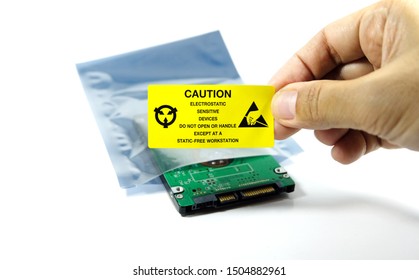 Hands of the engineers who are labeling the ESD protection label on the bag,The yellow CAUTION label for Electrostatic Sensitive Devices (ESD) on static free workstation.