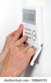 Hands Entering A Code To Burglar Alarm