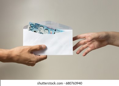 Hands and envelope with philippines peso inside