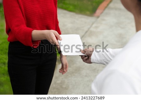 Hands exchanging a blank leaflet, revealing a moment of potential communication.