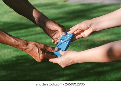 Hands Exchanging Gift Box Outdoors on Father's Day - Powered by Shutterstock