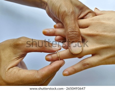 hands exchanging wedding ring during engagement ceremony symbolizing love, commitment, partnership, and romantic union forever