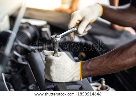 Hands Expertise car mechanic in auto repair service. Car maintenance and auto service garage concept. 