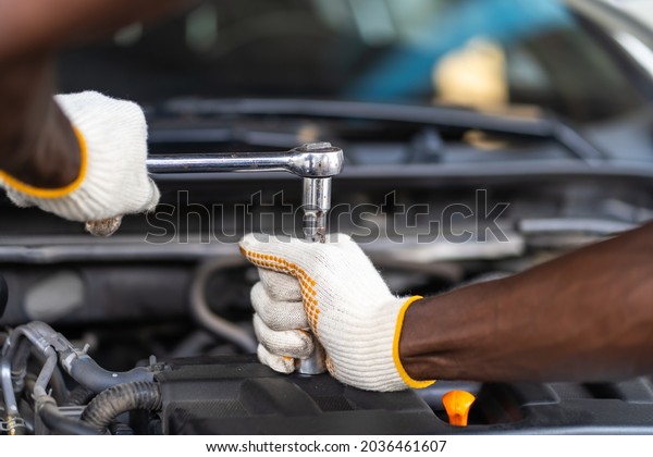 Hands Expertise car\
mechanic in auto repair service. Car maintenance and auto service\
garage concept. 