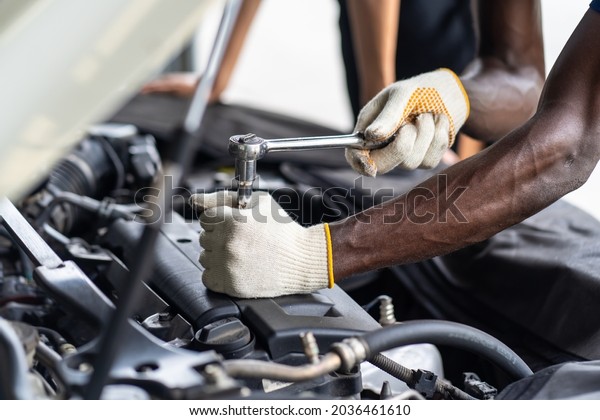 Hands Expertise car\
mechanic in auto repair service. Car maintenance and auto service\
garage concept. 