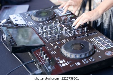 Hands Of Female DJ Using Digital Mixer.