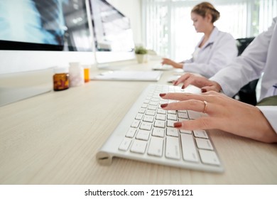 Hands Of Female Doctor Typing On Computer Keyboard