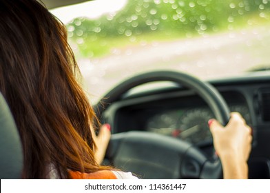 Hands of a female driver on steering wheel