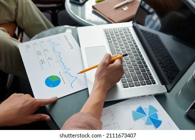 Hands Of Female Entrepreneur Discussing Chart Illustrating Website Visitors Activity With Colleague At Meeting