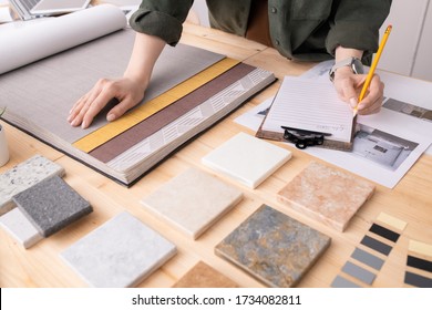 Hands Of Female Interior Designer With Pencil Over Paper Making Notes About Color, Pattern And Texture Of Wallpapers For New Client