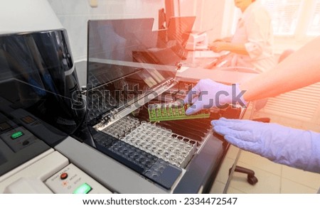 Hands of a female laboratory assistant loading a sample for the analysis of chemical tests