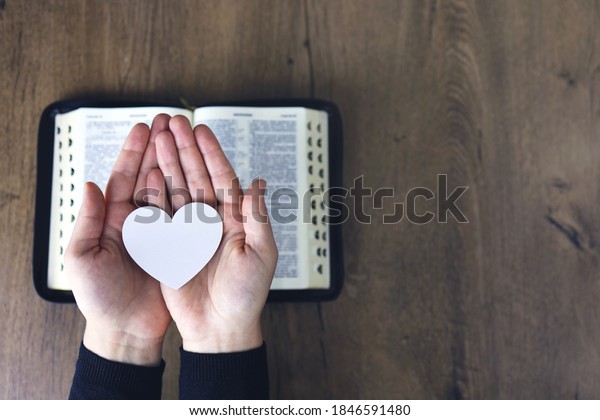 Hands\
female prayer to Load with broken heart in hands on the\
bible,Concept Pray for liberation,sin,no\
freedom.