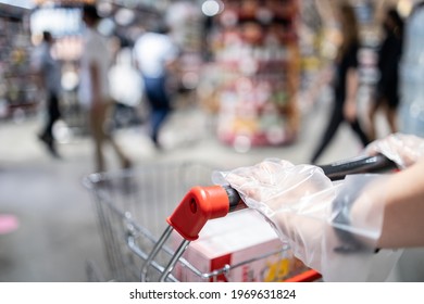 Hands Of Female Wearing Plastic Gloves Pushing A Shopping Cart To Prevent Spread Infection Of COVID-19,Coronavirus,plastic Gloves Service From The Supermarket Before Shopping Food,safety,health Care