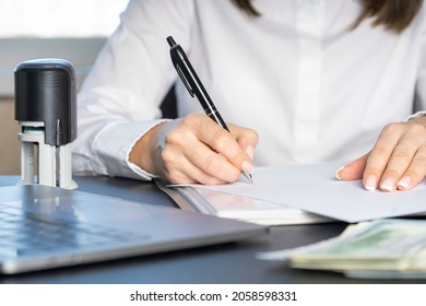 Hands of a financial worker in a white shirt signing a document. Workflow in accounting close-up.